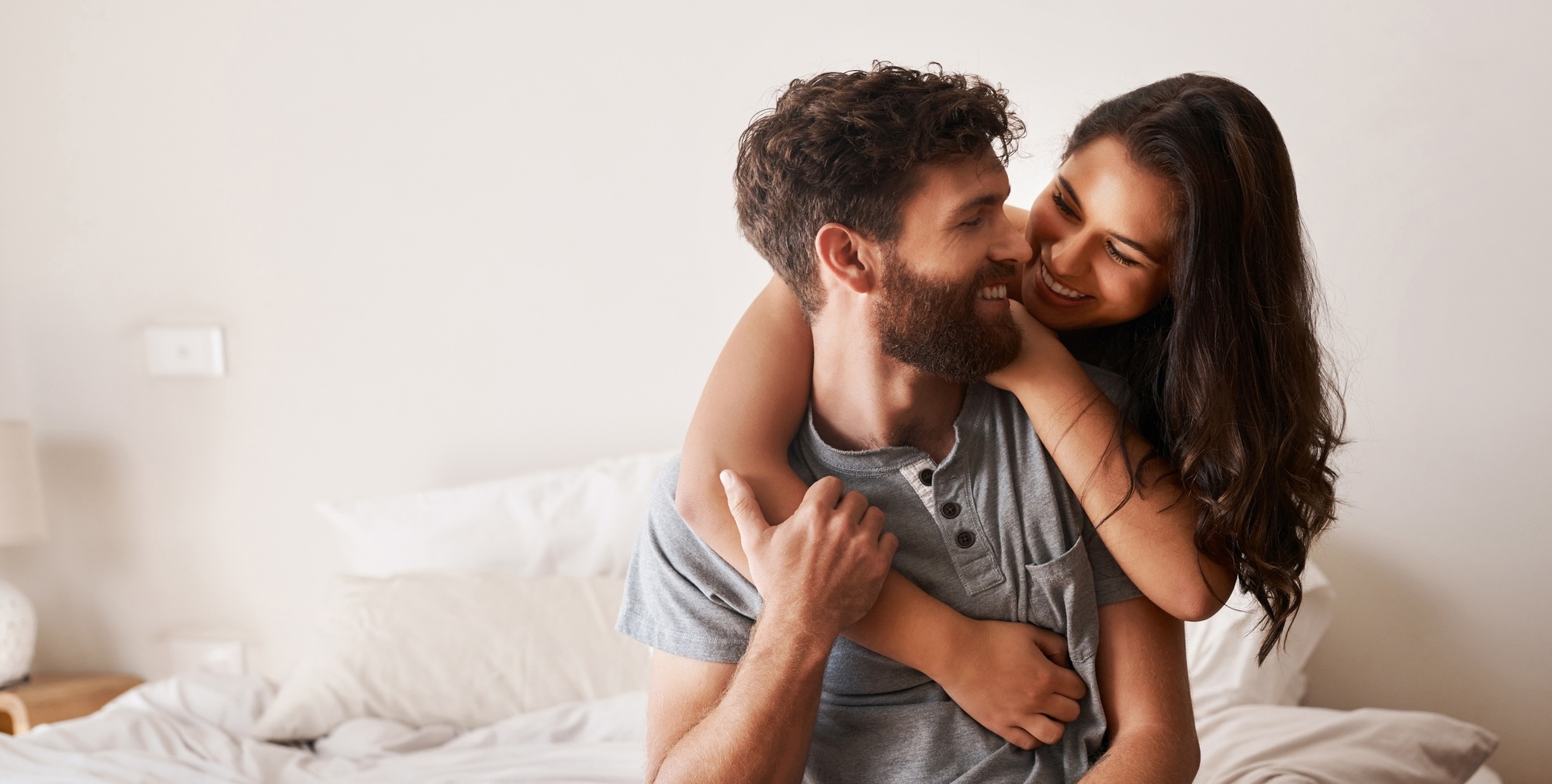 Photo of a happy couple in bed after GAINSWave® Therapy