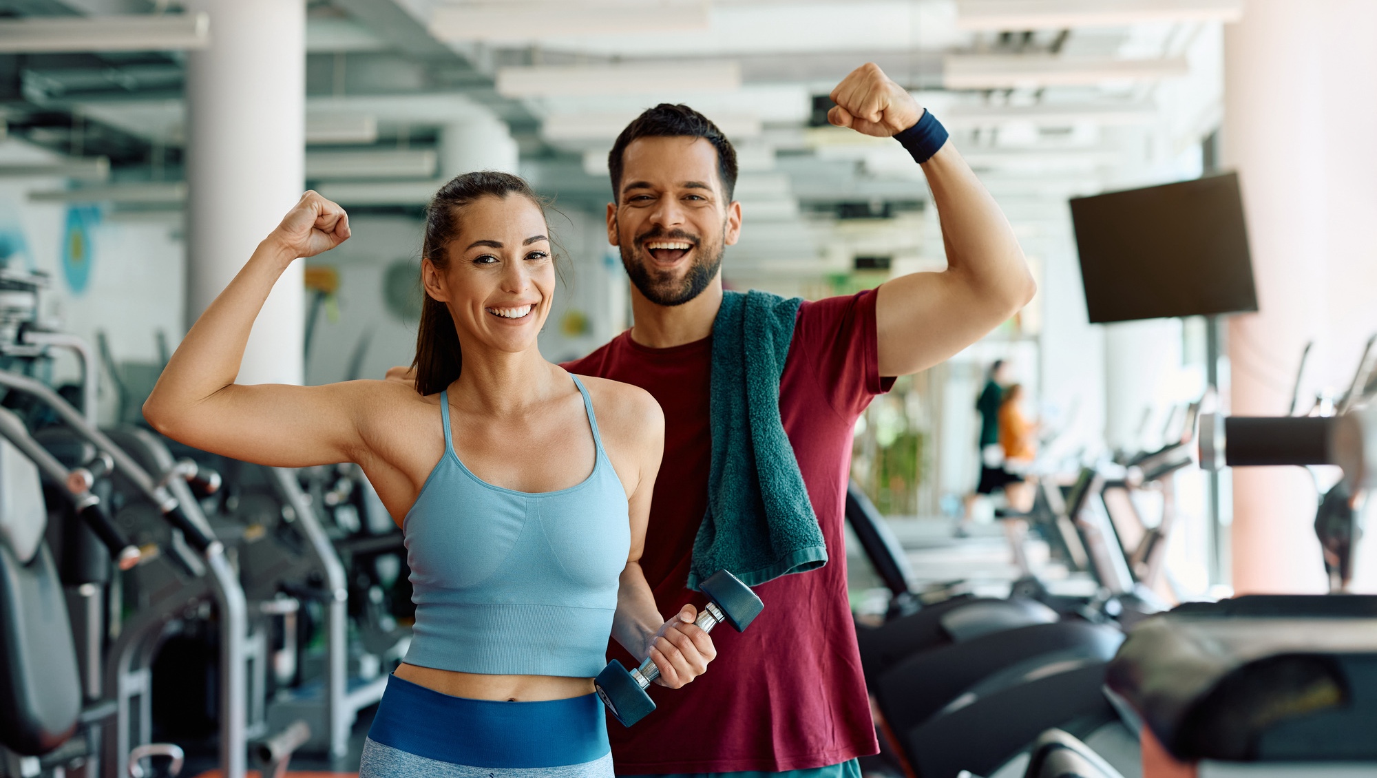 Photo of a couple flexing at the gym after muscle sculpting treatments