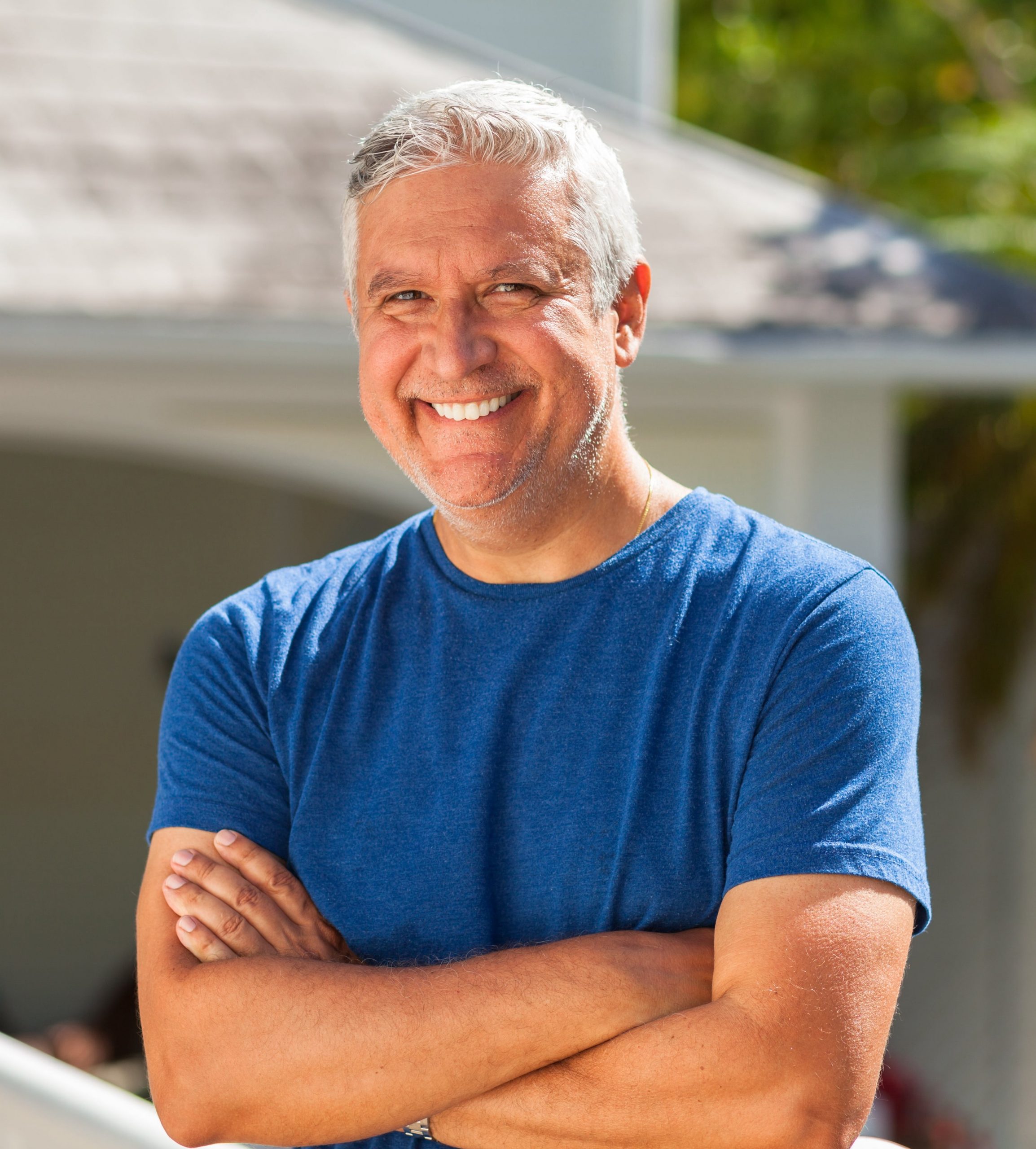 Photo of a handsome older man smiling and wearing a blue shirt