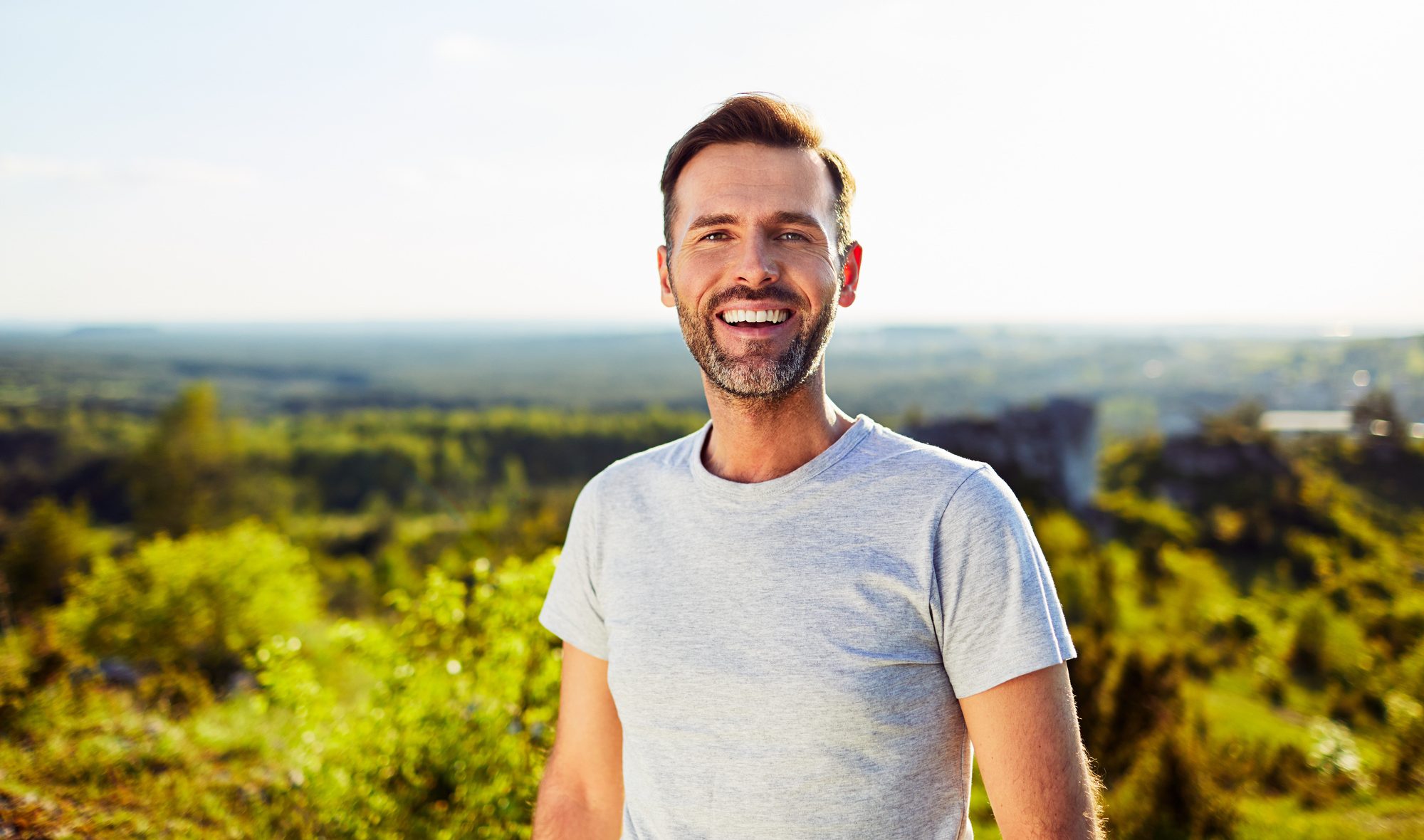 Portrait of happy adult man smiling outdoors after andropause treatment