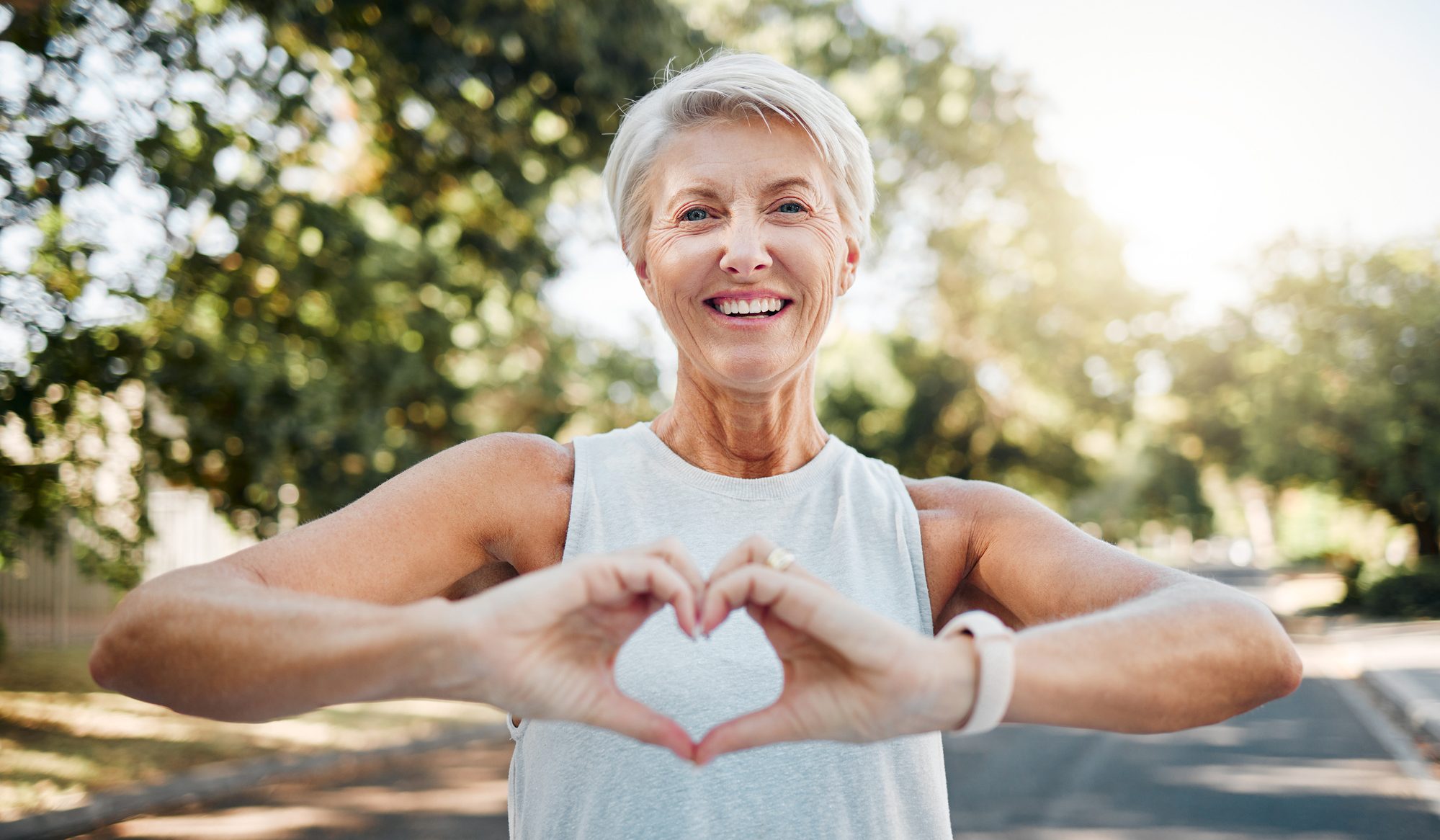 Photo of a healthy older woman making a heart shape with her hands