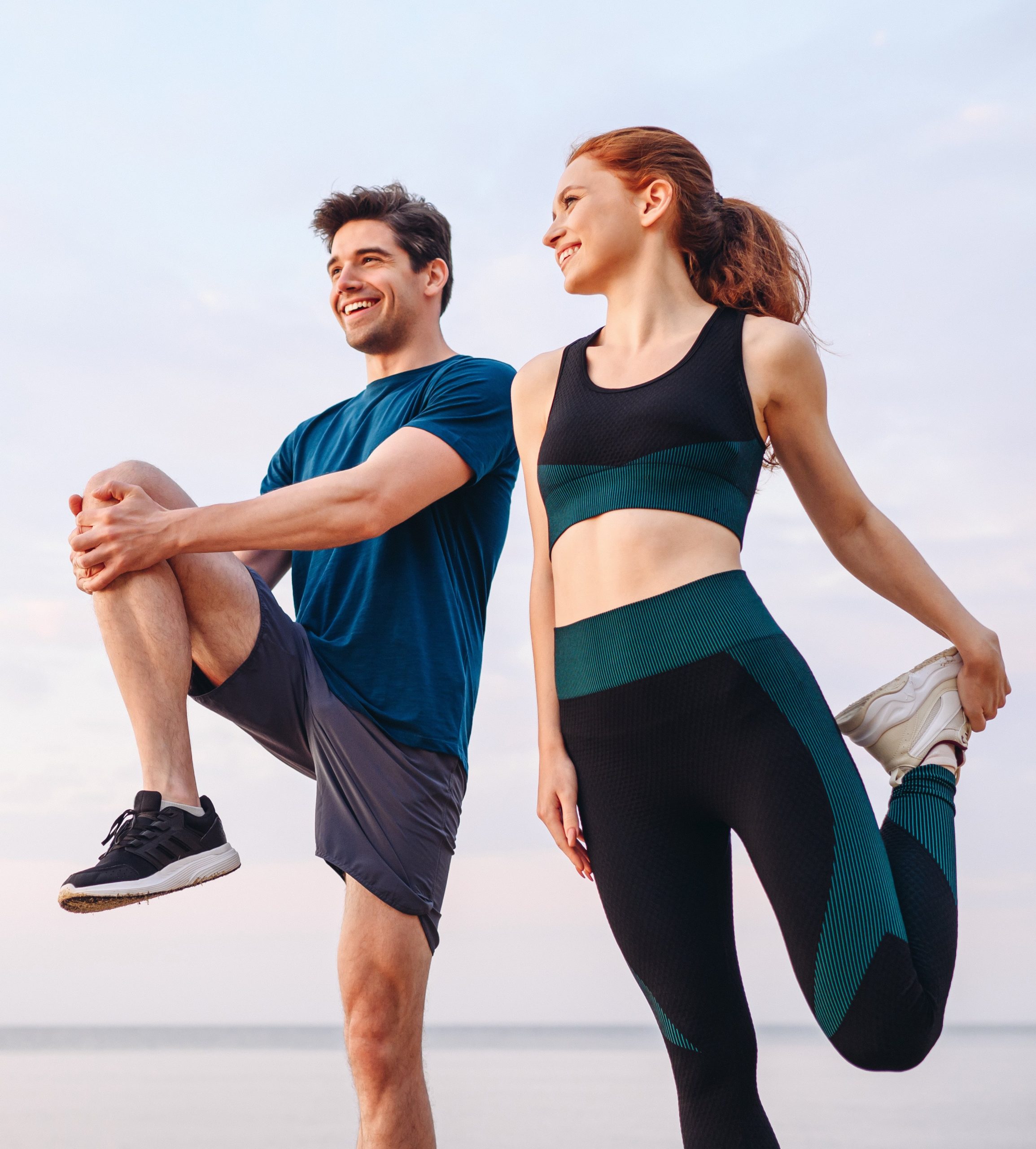 Photo of a fit couple in workout clothes stretching before a run