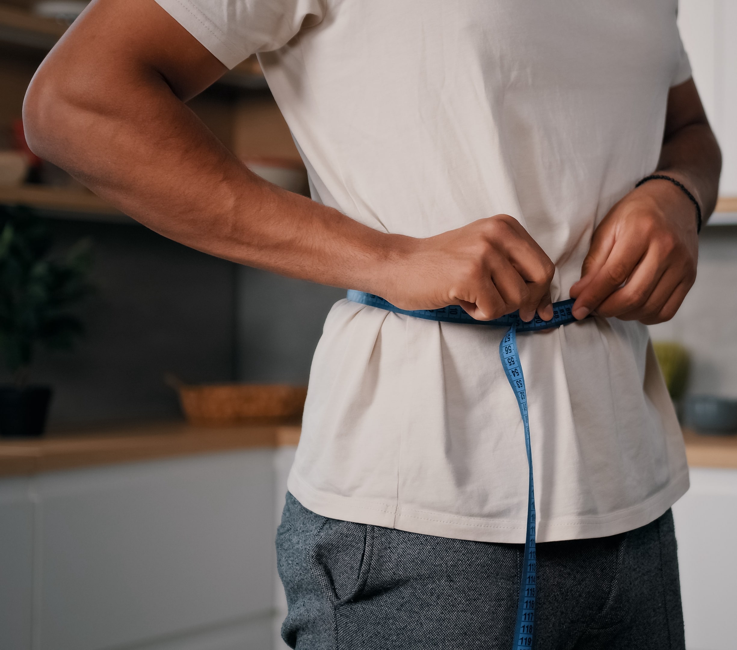 Photo of a man measuring his waistline