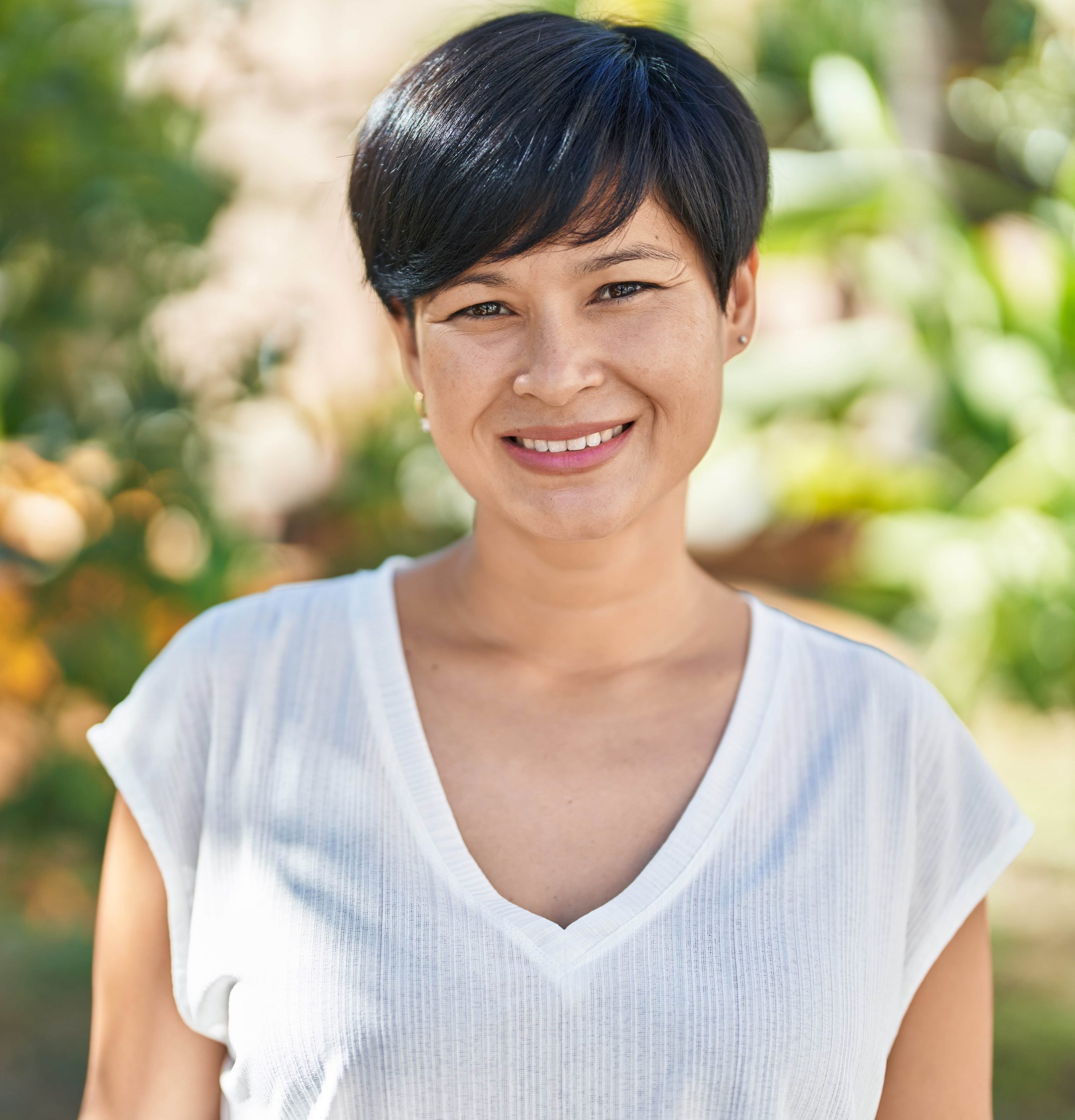 Photo of a woman with short hair wearing a white shirt outside