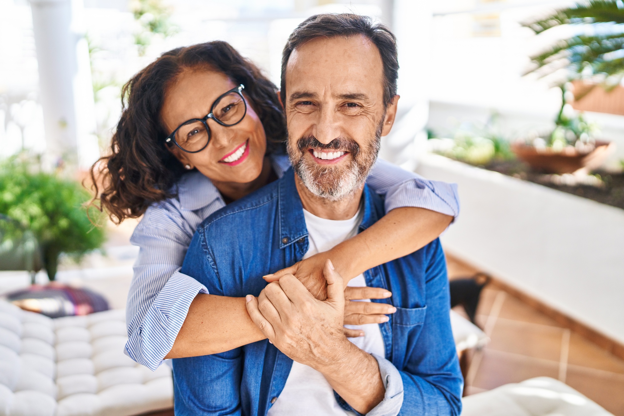 Middle age hispanic couple smiling confident hugging each other after bioidentical hormone therapy