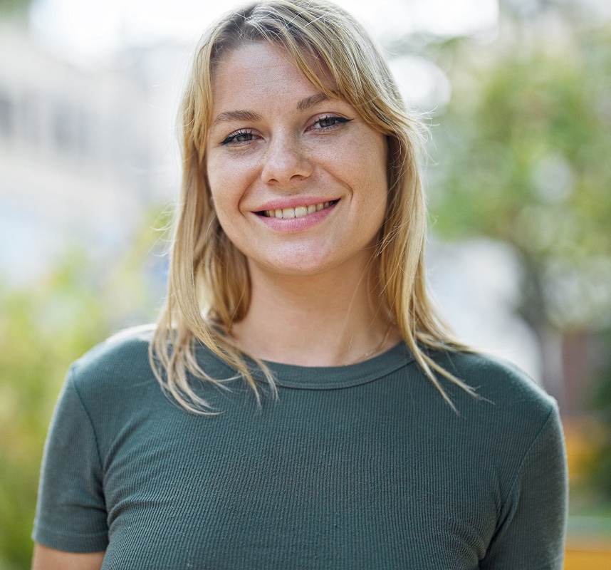 Young blonde woman smiling confident standing at park