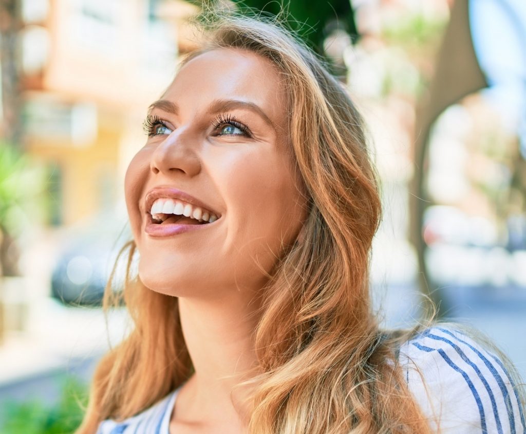 Young beautiful caucasian woman with blond hair smiling after lip enhancement treatments