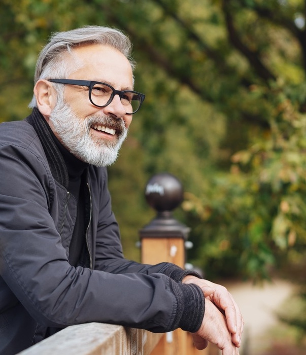 Happy bearded middle-aged man leaning on a parapet