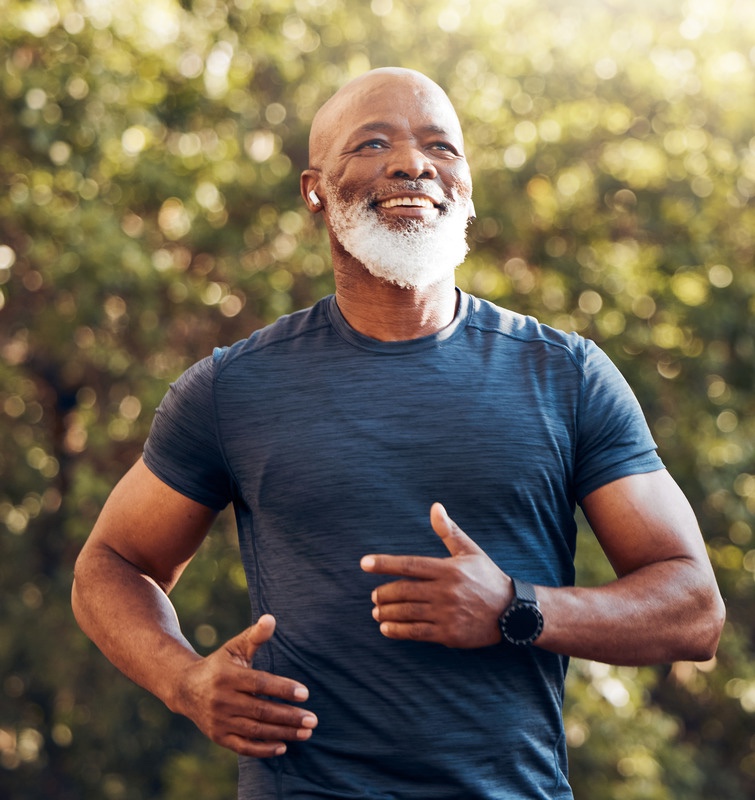 Happy man running in a park while listening to music on his airpods